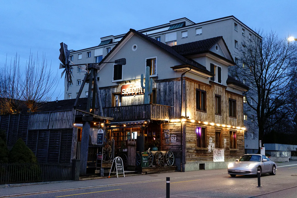 Der «Saloon» ist aber bereits jetzt offen. Haus im Westernstil mit grossem Windrad von aussen fotografiert.